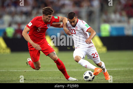 L'Inghilterra del John pietre (sinistra) e della Tunisia è Naim Sliti (destra) battaglia per la sfera durante la Coppa del Mondo FIFA Gruppo G corrisponde all'Arena di Volgograd, Volgograd. Foto Stock