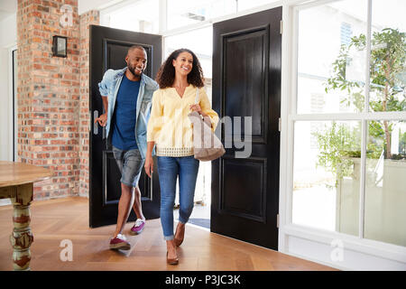 Giovani razza mista giovane arrivando a casa Foto Stock