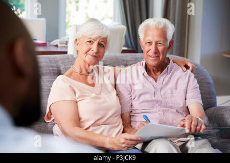 Felice coppia senior tenendo la consulenza finanziaria a casa Foto Stock
