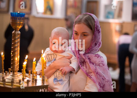 La Bielorussia, Gomel, febbraio 24, 2018. Chiesa di betulle.Il battesimo del bambino.Bambino nelle braccia della madre.Il battesimo del bambino. Accettare la fede. N Foto Stock