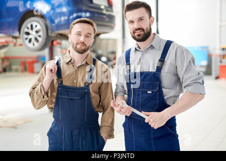 Due lavoratori che pongono in Car Service Shop Foto Stock