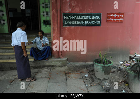 Yangon, Myanmar, uomini di fronte a una succursale di Myanma Banca economica Foto Stock