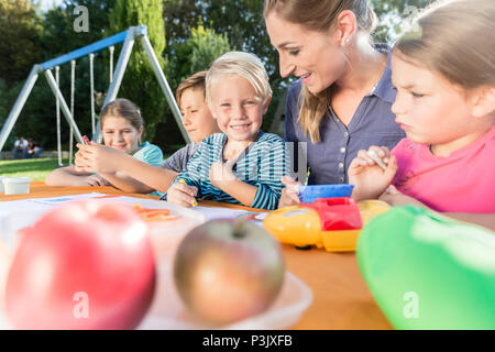 La mamma le foto di pittura con i suoi bambini Foto Stock