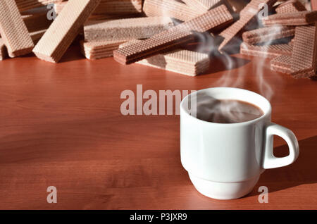 Una tazza di caffè caldo e una manciata di classico russo cialde con diversi riempimenti su un marrone la superficie di legno. Still-life di mattina festa, concetto s Foto Stock