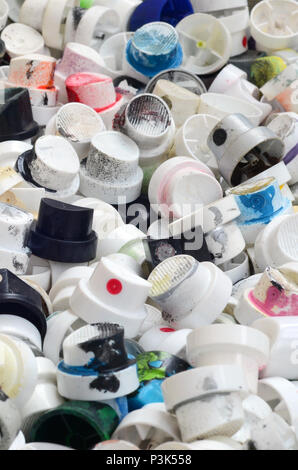 Un modello di molti impiegati e sporco ugelli da bombolette spray con bomboletta di vernice spray. Texture di sfondo della street art di disegnare graffiti sulle pareti Foto Stock