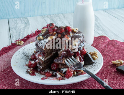 Deliziose frittelle di cioccolato - dessert gourmet per colazione? Primo piano di una pila di frittelle farcite con ciliegie, panna e noci. Varie angolazioni Foto Stock