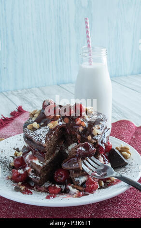 Deliziose frittelle di cioccolato - dessert gourmet per colazione? Primo piano di una pila di frittelle farcite con ciliegie, panna e noci. Varie angolazioni Foto Stock