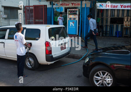Yangon, Myanmar, un gas station attendant effettua il rifornimento di carburante di un veicolo in corrispondenza di una stazione di gas Foto Stock