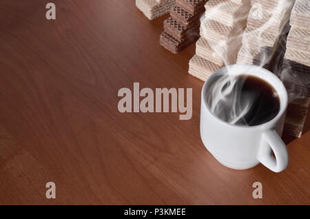 Una tazza di caffè caldo e una manciata di classico russo cialde con diversi riempimenti su un marrone la superficie di legno. Still-life di mattina festa, concetto s Foto Stock