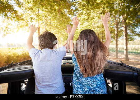 I bambini in piedi nel retro della parte superiore aperta su Auto Road Trip Foto Stock