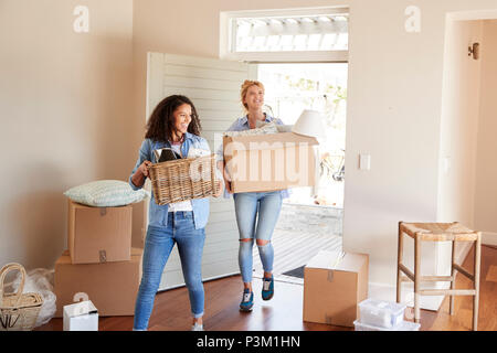 Amici di sesso femminile che trasportano le caselle nella nuova casa il giorno del trasloco Foto Stock