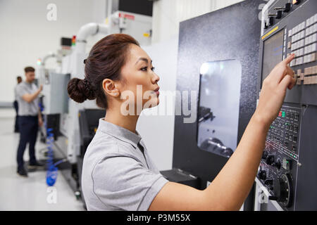 Femmina di funzionamento tecnico di macchine CNC in fabbrica Foto Stock