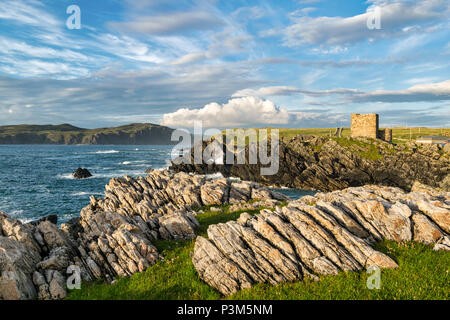 Questa è una foto di Castello Carrickabraghy in Donegal Irlanda. La linea costiera qui è molto roccioso. La fotografia è stata scattata al tramonto Foto Stock