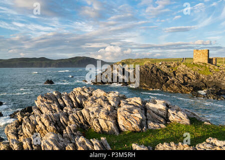 Questa è una foto di Castello Carrickabraghy in Donegal Irlanda. La costa linie sentire è molto roccioso. La fotografia è stata scattata al tramonto Foto Stock