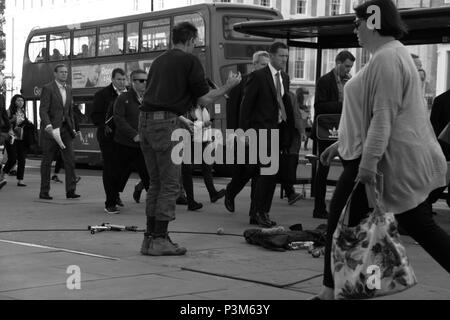 Giocoliere tenta di intrattenere i pendolari e i lavoratori di office su London Bridge, London, England, Regno Unito, Peter Grant Foto Stock