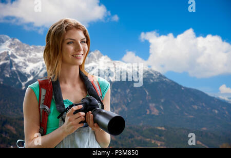 Donna con zaino e telecamera oltre le montagne delle Alpi Foto Stock