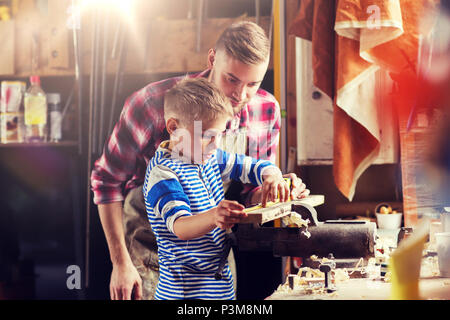 Padre e Figlio con il righello di legno di misura in officina Foto Stock