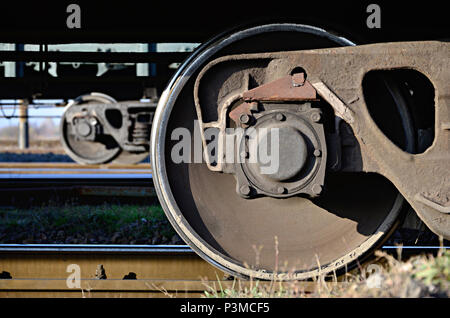 Foto dettagliate del trasporto merci ferroviario auto. Un frammento di parti dei componenti del carro merci su ferrovia in condizioni di luce diurna Foto Stock