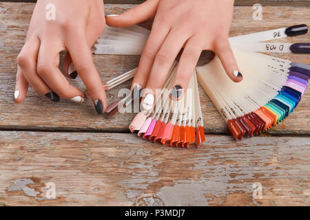 Giovane donna mani scegliendo il colore delle unghie. Foto Stock