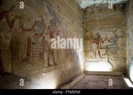 Verniciato colorato bassorilievo incisioni raffigurano il faraone e la divinità egiziane all'interno del grande Osiride tempio costruito da Pepi I, Abydos, Egitto. Foto Stock