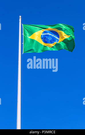 Bandiera del Brasile battenti nel vento contro il cielo blu Foto Stock
