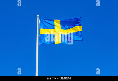 Bandiera della Svezia battenti nel vento contro il cielo blu Foto Stock
