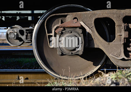 Foto dettagliate del trasporto merci ferroviario auto. Un frammento di parti dei componenti del carro merci su ferrovia in condizioni di luce diurna Foto Stock