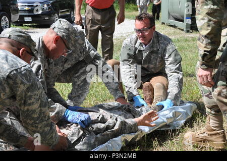 Sgt. Jeremy Woods (centro sinistra), un medico di corsie istruttore presso il Camp Dodge manovra comune centro di formazione, Johnston, Iowa, aiuta il suo team medico caricare una simulazione di incidente su una barella con l'assistenza del Segretario dell'esercito Eric Fanning, chi tiene la vittima i piedi. Il Segretario ha ricevuto una informativa a mani sul breve come egli ha visitato il supporto Training Center sito di formazione su Camp Dodge. (U.S. Foto dell'esercito da Master Sgt. Duff E. McFadden/rilasciato) Foto Stock