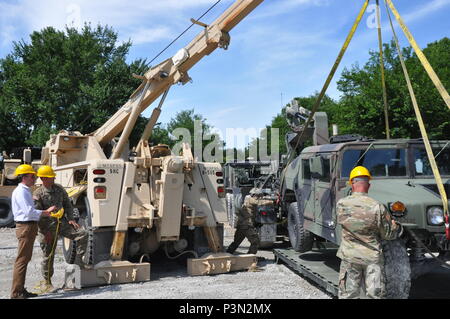 Iowa nazionale soldati di guardia consentono di posizionare una fionda HMMWV caricato (Humvee) su un flat rack, come segretario dell'esercito Eric Fanning manovre del veicolo utilizzando un agguato Mine-Resistant protetto (MRAP) wrecker. Il Segretario ha ricevuto una informativa e le mani sul briefing come egli visitando il supporto Training Center all'Iowa Guardia Nazionale's Camp Dodge manovra comune centro di formazione in Johnston, Iowa. (U.S. Foto dell'esercito da Master Sgt. Duff E. McFadden/rilasciato) Foto Stock