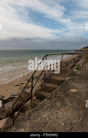 Una serie di passaggi che conducono giù sulla spiaggia a Totland Bay sull'isola di Wight. bella e atmosferica seascape con interessanti formazioni di nubi. Foto Stock