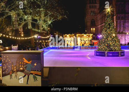 London, Regno Unito - Dicembre 2017. Vista notturna della pista di pattinaggio su ghiaccio e la giostra presso il Museo Nazionale di Storia, con decorazioni di Natale. Foto Stock