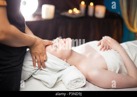 Salubre e tempo libero. Soddisfatto donna con massaggio viso nel complesso termale. Foto Stock