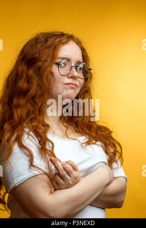 Redhaired donna con negativo a un'espressione facciale umana. Foto Stock