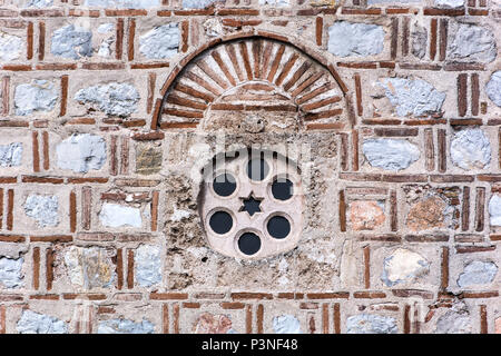 Vecchia finestra in pietra e la facciata sulla moschea. Stile islamico di decorazione e di pattern con cerchio e stella. La religione storica del concetto. Close up, il fuoco selettivo Foto Stock