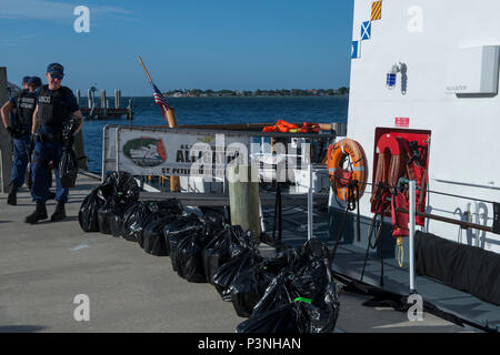 Coast Guard funzionari di polizia a bordo del guardacoste offload del coccodrillo di circa 150 chilogrammi di cocaina del valore di 5 milioni di dollari stimati valore all'ingrosso a Coast Guard Settore San Pietroburgo, Florida, Lunedì 18 Luglio, 2016. La cocaina è stata sequestrata nel corso di due distinti interdictions nel Mar dei Caraibi come parte di Operazione Unified risolvere. (U.S. Coast Guard foto di Sottufficiali di seconda classe Ashley J. Johnson) Foto Stock