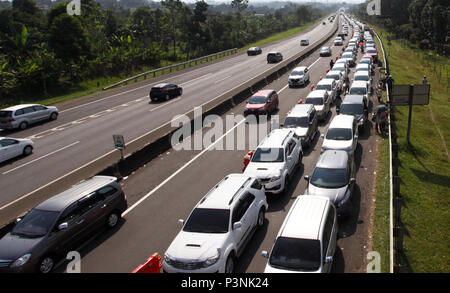 Bogor, Indonesia. Il 18 giugno, 2018. La coda di veicoli assiepati fuori Gadog casello Ciawi verso Puncak, Bogor, West Java, Indonesia. Bogor ufficiali del traffico registrato il numero di veicoli in entrata Il Puncak tour quanto 33,754 veicoli che desiderano una vacanza all'Eid Al-Fitr holiday istante in modo da applicare un sistema a senso unico per ridurre la densità nella regione. Credito: Adriana Adinandra/Pacific Press/Alamy Live News Foto Stock