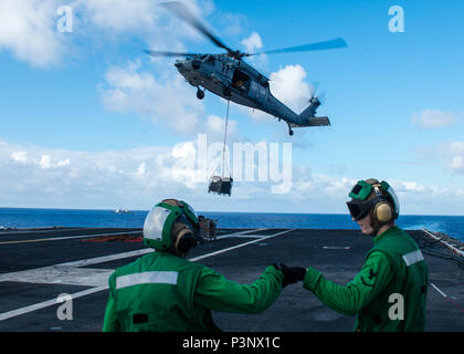 160718-N-MIA174-073 OCEANO PACIFICO (18 luglio 2016) marinai celebrare dopo carico di aggancio ad un MH-60S Sea Hawk assegnati per i caricatori di elicottero di mare squadrone di combattimento (HSC) 14 sulla USS John C. Stennis' (CVN 74) ponte di volo durante un rifornimento in mare con fast combattere la nave appoggio USNS Ranieri (T-AOE 7) durante il cerchio del Pacifico 2016. Venti-sei nazioni, più di 40 navi e sottomarini, più di 200 aerei e 25.000 personale partecipano RIMPAC dal 30 giugno al 4 agosto, in e intorno alle Isole Hawaii e la California del Sud. Il più grande del mondo marittimo internazionale di esercizio Foto Stock