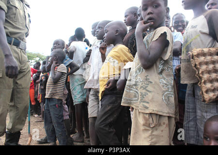 I bambini guardano come un poliziotto passa da in Uganda Foto Stock