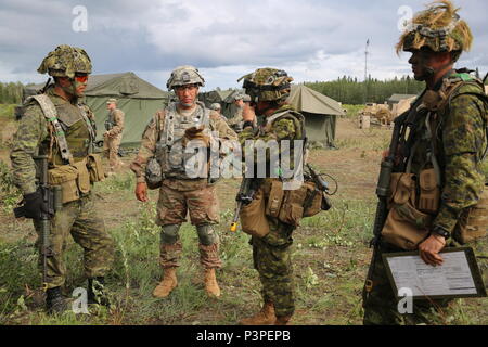Il Mag. Chelsea Braybrook, commander, Bravo Company, 1° Battaglione, Principessa di Patricia luce canadese compagnia di fanteria colloqui al comando Sgt. Il Mag. Michael Bartlett, CSM, 1° Stryker Brigade Combat Team, XXV divisione di fanteria durante #ArcticAnvil a Donnelly Area Formazione, Alaska Luglio 20. Foto Stock
