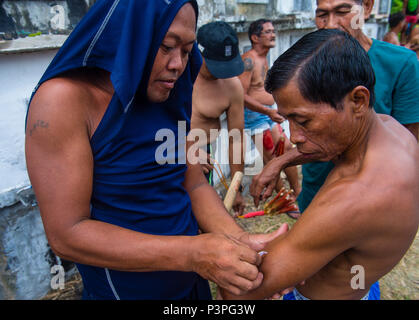 Filippino uomini hanno colpito themselve il Venerdì Santo al cimitero di Gasan, Marinduque Island, Filippine Foto Stock