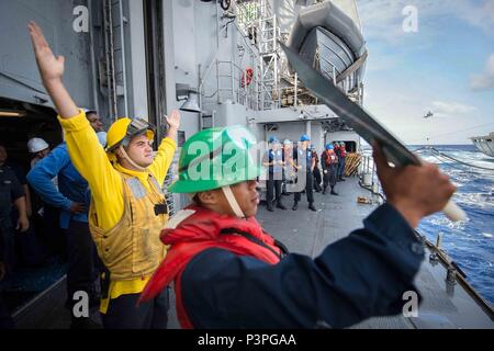 160722-N-EH218-229 OCEANO PACIFICO (Luglio 22, 2016) - Boatswain compagno del 3° di classe Geremia Benetti, da Smithfield, Rhode Island, dirige il trasferimento di negozi a bordo guidato-missili cruiser USS Mobile Bay (CG 53) durante la conduzione di un rifornimento collegato in mare con i militari Sealift Command (MSC) fast combattere la nave appoggio USNS Ranieri (T-AOE 7) durante il cerchio del Pacifico 2016. Venti-sei nazioni, più di 40 navi e sottomarini, più di 200 aerei e 25.000 personale partecipano RIMPAC dal 30 giugno al 4 agosto, in e intorno alle Isole Hawaii e la California del Sud. Th Foto Stock