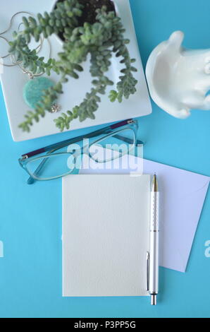 Blu Turchese vista superiore piatta in stile di layout desktop con notebook vuoto e auto per copia. Lavorando da casa in ufficio. Invito, il diario o biglietto di auguri. Foto Stock