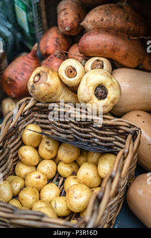 Il bianco e il rosso le patate in un cesto di vimini per la vendita su un mercato degli agricoltori in Cornovaglia, England, Regno Unito Foto Stock