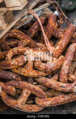 Pila di vecchi, grande e pesante rusty maglie di catena in un marina lo sbarco nel porto di pesca Foto Stock