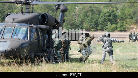 Un capo equipaggio con l'esercito Arizona Guardia Nazionale dirige i soldati tedeschi off a UH-60 Blackhawk elicottero in un area di assemblaggio a sostegno del prode Strike III, una multinazionale (polacco, ungherese, tedesco e le forze degli Stati Uniti) folla antisommossa esercizio condotta dalle forze del Kosovo (KFOR) a Camp Vrelo, Kosovo, luglio 27. Stati Uniti e le forze della NATO hanno contribuito alle Nazioni Unite-affidata la missione di mantenimento della pace in Kosovo a partire dal giugno 1999. (U.S. Foto dell'esercito da: Capt. Casey Martin, multinazionale battaglia Group-East Affari pubblici) Foto Stock