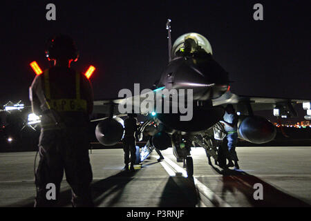 Stati Uniti Air Force Tech. Sgt. James Scott, primo piano, un flightline capo equipaggio con il New Jersey Air National Guard il 177th Fighter Wing, lavora alla fine della pista con altri membri della 177th squadrone di manutenzione al fine di lanciare un F-16 Fighting Falcon durante le operazioni notturne come parte di bandiera rossa 16-3, luglio 13, 2016 su alla Nellis Air Force Base, Nev. (U.S. Air National Guard foto di Senior Airman Shane Karp/rilasciato) Foto Stock