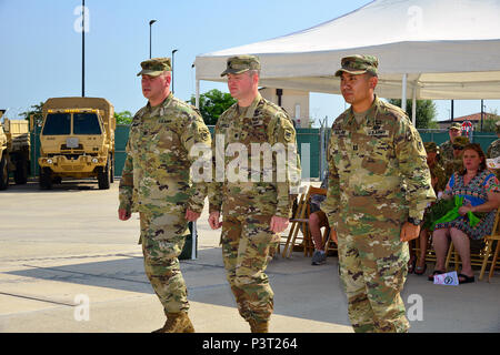 LT. Col. Brett M. Medlin, centro, comandante della U.S. Army Africa sede e Sede battaglione, sede in uscita supporto azienda commander Capt. Nicholas F. barbiere, sinistra e comandante in arrivo Capt. Jeremy K. Galvez, destra, procedere in avanti per scambiare il guidon durante la modifica del comando cerimonia alla Caserma del Din, luglio 29, 2016. (U.S. Esercito foto di Visual Information Specialist Antonio Bedin/rilasciato) Foto Stock