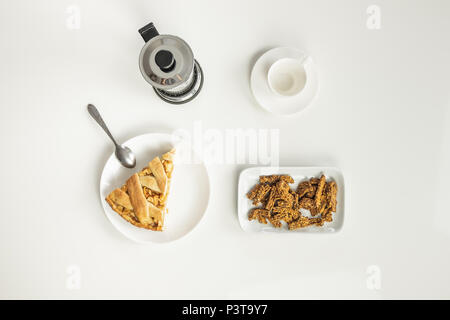 Vista superiore del tavolo minimalista con pranzo di lavoro con caffè, cereali e applicano una torta. Concetto di colazione veloce pasto con french press coffee brewer Foto Stock