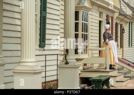 Donna vestito in abiti storici in piedi di fronte a una casa Foto Stock