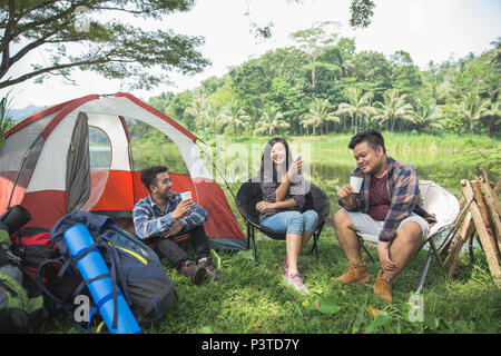 Amici al di fuori di rilassante tende sul Camping Foto Stock